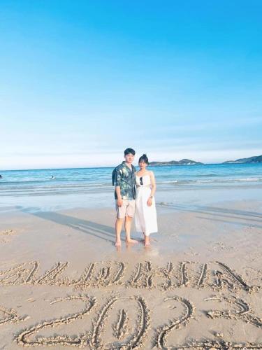 a bride and groom standing in the sand on the beach at Aloha Bình Tiên-Thôn Bình Tiên, Công Hải, Thuận Bắc, Ninh Thuận, Việt Nam in Phan Rang