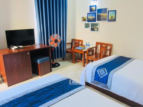 een slaapkamer met een bed en een bureau met een computer bij Aloha Bình Tiên-Thôn Bình Tiên, Công Hải, Thuận Bắc, Ninh Thuận, Việt Nam in Phan Rang