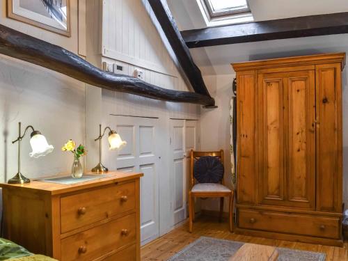 Swinside Cottage في Ennerdale Bridge: غرفة نوم مع خزانة خشبية وخزانة