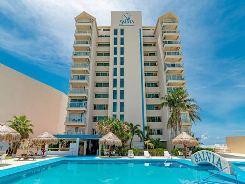 a hotel with a swimming pool in front of a building at Beachfront Penthouse (best location, 3 beds, 2 balconies) in Cancún