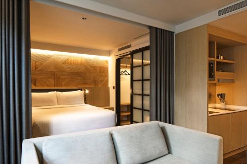 a hotel room with a bed and a couch at KēSa House, The Unlimited Collection managed by The Ascott Limited in Singapore