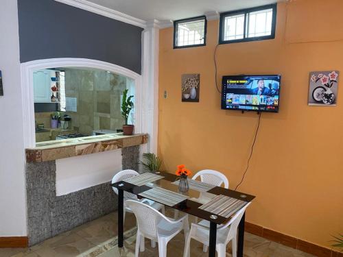 a dining room with a table and a television on the wall at Departamentos en la Garzota cerca del Aeropuerto Norte de Guayaquil in Guayaquil