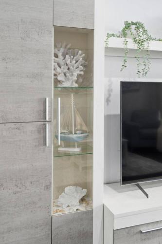 a living room with a tv and a shelf at City Beach Escape - Wollongong Waterside Serenity in Wollongong