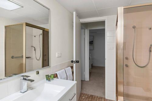 a bathroom with a sink and a shower and a mirror at Esplanade Escape - Beachfront Family Bliss in Thirroul