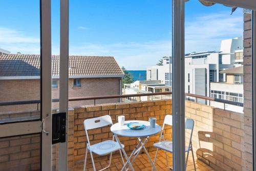 a balcony with a table and chairs on a balcony at North Beach Escape - Balcony Sunrises and Ocean Walks in Wollongong