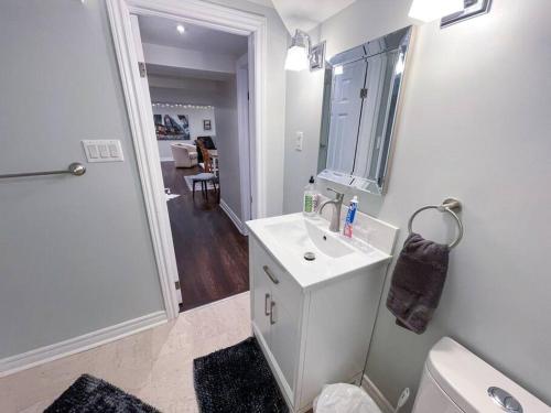 uma casa de banho com um lavatório, um WC e um espelho. em Spacious & Renovated 1BD Suite w/parking em Toronto
