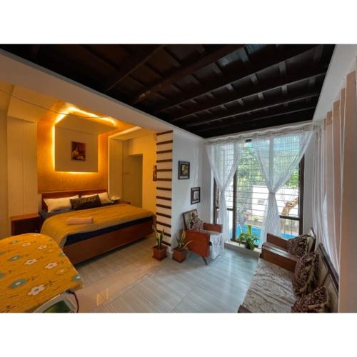 sypialnia z łóżkiem i dużym oknem w obiekcie The Heritage Villa - Poovar w mieście Neyyāttinkara