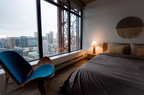 a bedroom with a bed and a large window at 34th-Floor Gastown 2BR with Parking & Harbour Views in Vancouver