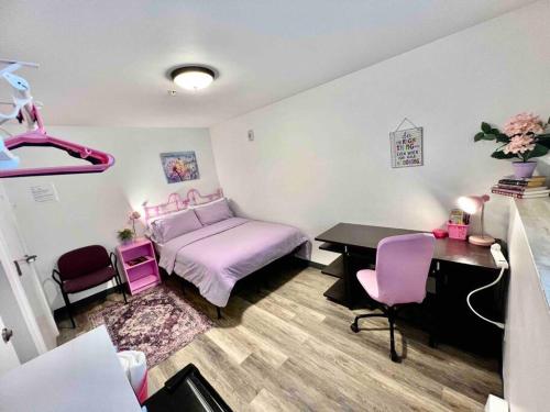 a bedroom with a bed and a desk and pink chairs at Apartment Studio with Shared Bathroom on the 1st Floor 10 minutes walk to University of WA in Seattle