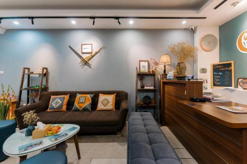 a living room with a couch and a clock on the wall at Cheers Hostel Hanoi in Hanoi