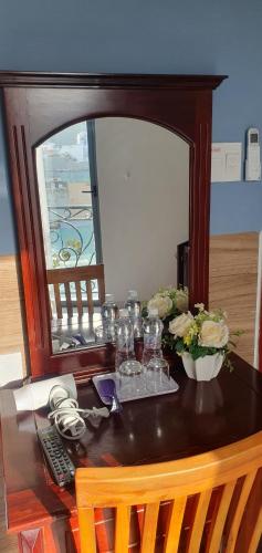 a table with glasses and flowers on top of it at LUCKY HOTEL in Vung Tau