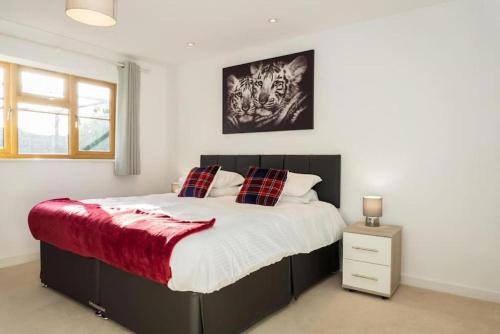 a bedroom with a large bed with a red blanket at Modern 4 Bed Detached Private House-Parking-Garden in Down Hatherley