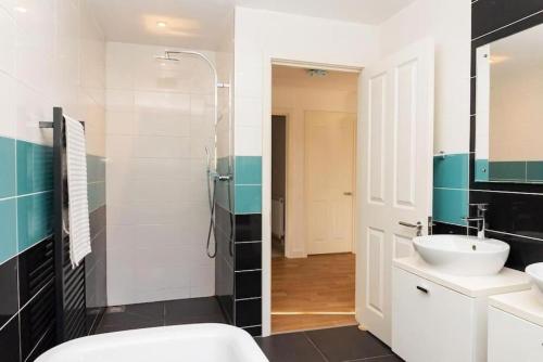 a bathroom with a sink and a toilet and a mirror at Modern 4 Bed Detached Private House-Parking-Garden in Down Hatherley