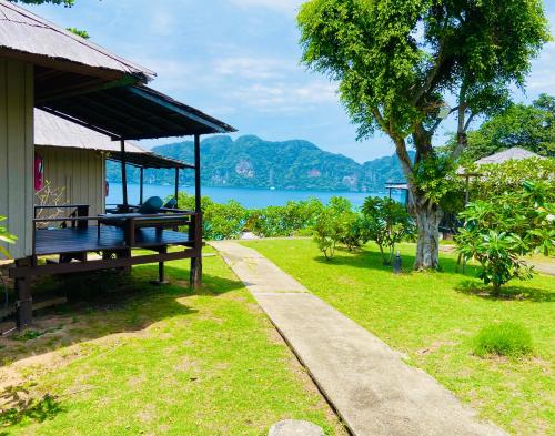 a house with a bench next to a grass field at HIP Seaview Resort @ Phi Phi in Phi Phi Don