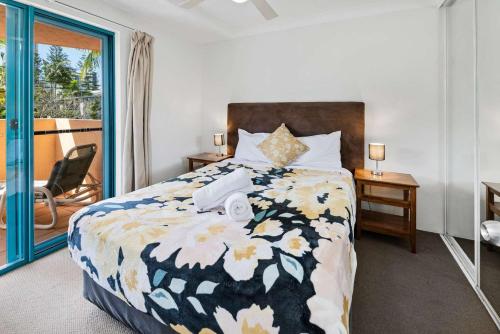 a bedroom with a bed and a balcony at Karana Palms Resort in Gold Coast