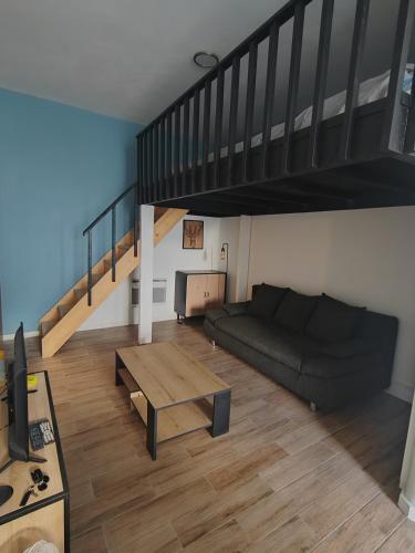 un salon avec un canapé et un escalier dans l'établissement Bel appartement, à Nîmes