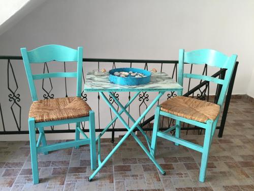 stół z dwoma krzesłami i miską owoców na nim w obiekcie Icthyoessa w Agios Kirykos