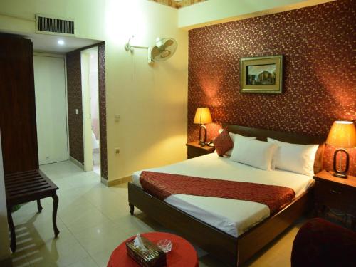 a hotel room with a bed and a bathroom at Luxury one hotel Lahore in Lahore