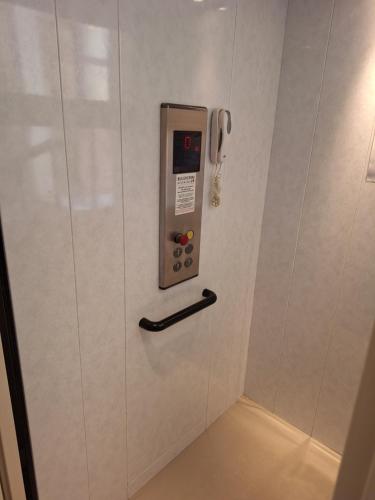 a phone is on the wall of a bathroom at Pigiotto in Pesaro