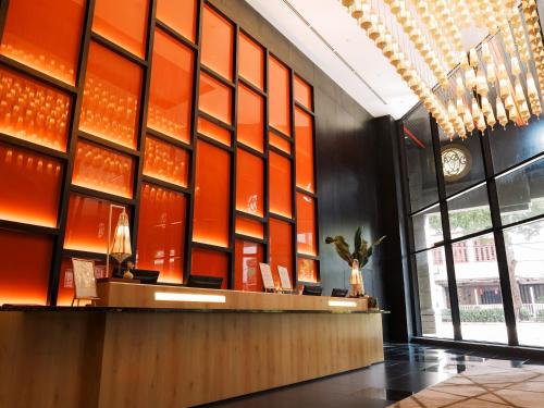 um átrio com uma parede laranja em Stay Collection Bukit Bintang em Kuala Lumpur