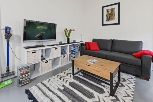 a living room with a couch and a tv at Parsons Flat River Barn in Dargo