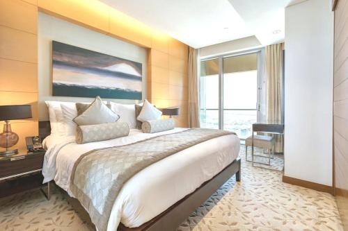 een slaapkamer met een groot bed en een groot raam bij Address Dubai Mall Exclusive in Dubai