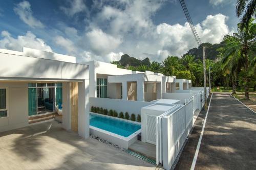 奧南海灘的住宿－The Haven Krabi，一座白色的房子,前面设有一个游泳池