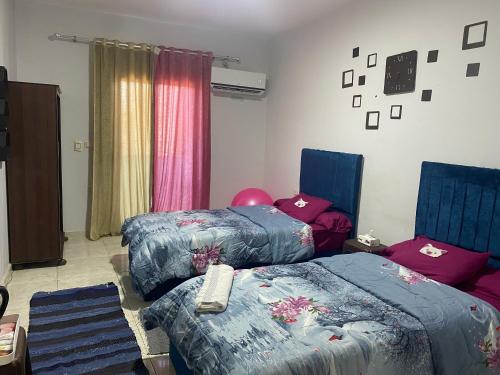 1 dormitorio con 2 camas, mesa y ventana en Zein Pyramids View - Guest House en El Cairo