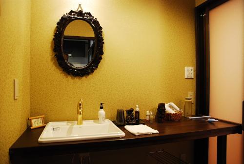 a bathroom with a sink and a mirror on the wall at 金沢一棟宿 海泉 Restoring In Kanazawa KAISEN in Kanazawa