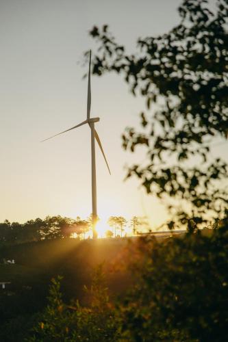 a wind turbine with the sun in the background at Cloud9 & Cloud View Glamping in Da Lat
