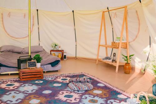 a bedroom with a tent with a bed and a rug at Cloud9 Glamping & Cafe in Xuân Trường