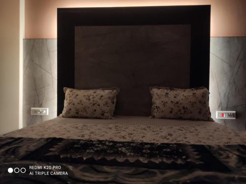 a bed with a black headboard and two pillows at WinterValleyChail in Shimla