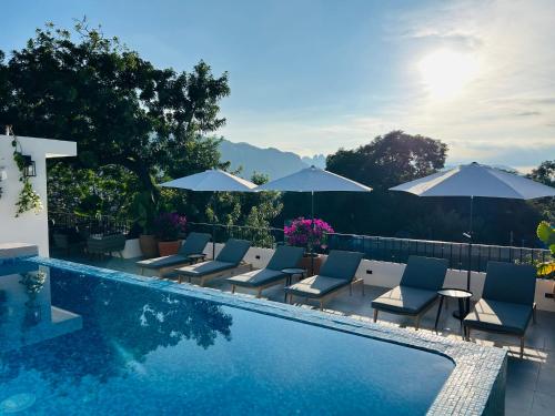 a swimming pool with lounge chairs and umbrellas at Tatala Hotel & Garden in Tepoztlán