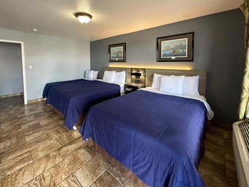 duas camas num quarto de hotel com lençóis azuis em Coastal Bend at Seadrift, Motel & RV Park em Seadrift