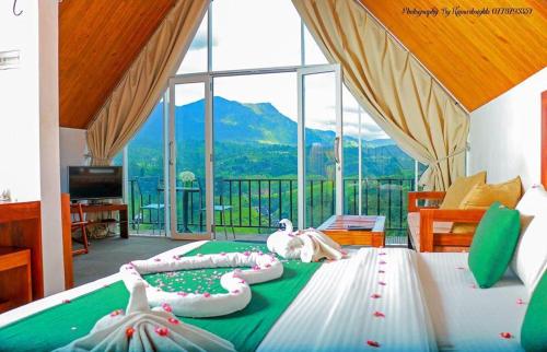 1 dormitorio con 1 cama y vistas a la montaña en Waterfalls View Resort, en Talawakele