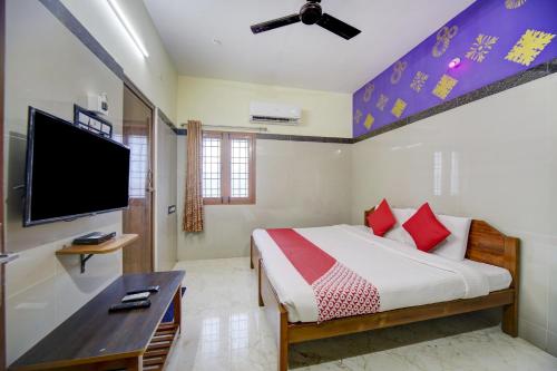 a bedroom with a bed and a flat screen tv at Super OYO Green Park in Vellore