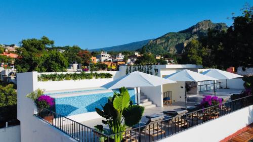 een resort met een zwembad en parasols bij Tatala Hotel & Garden in Tepoztlán
