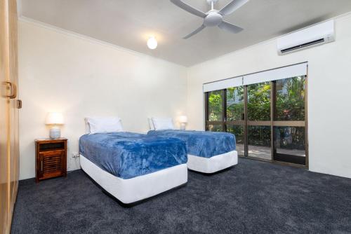 1 dormitorio con 2 camas y ventilador de techo en Villa 5 Marlin Terraces, en Port Douglas