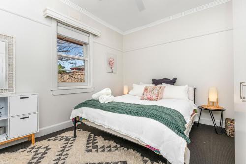 a white bedroom with a bed and a window at Golden Square Gold Class Guest House, Bendigo in Golden Square