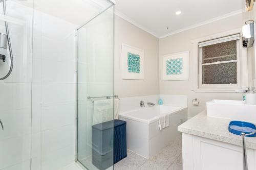 a white bathroom with a shower and a sink at Golden Square Gold Class Guest House, Bendigo in Golden Square