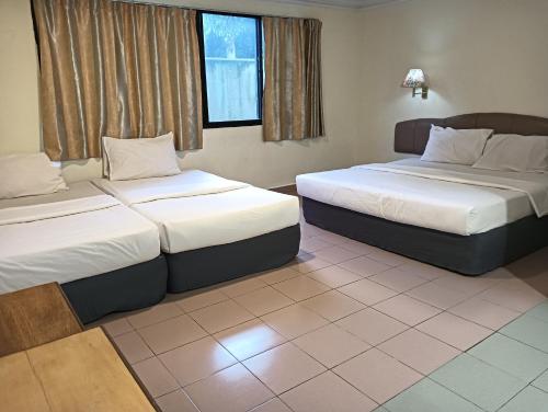 una camera d'albergo con due letti e due finestre di OYO 90860 Wawasan Inn a Sarikei