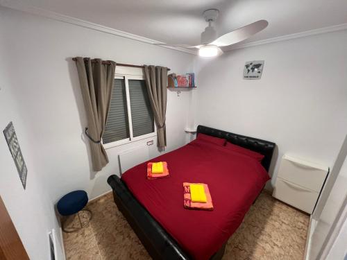 1 dormitorio con 1 cama roja y 2 carpetas amarillas en Saint James Park downstairs, en Orihuela