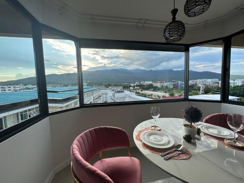 a dining room with a table and chairs and windows at Mountain & City View Panorama at Nimman in Chiang Mai