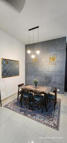 uma sala de jantar com uma mesa e cadeiras num tapete em D'Haty Homestay em Padang Serai