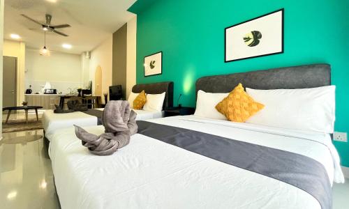 - 2 lits dans une chambre avec un mur vert dans l'établissement Core Soho Designer Suite @ KLIA, à Sepang