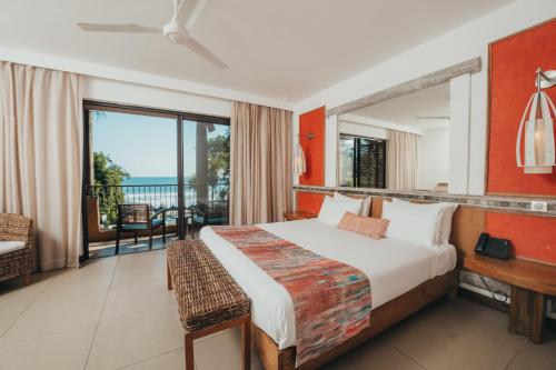 a bedroom with a bed and a view of the ocean at Tamarina Golf & Spa Boutique Hotel in Flic-en-Flac