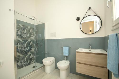 een badkamer met een toilet, een wastafel en een spiegel bij Casuzza bedda in Casteldaccia