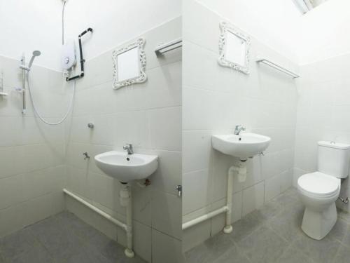 a white bathroom with a toilet and a sink at Amida Point in Kuching