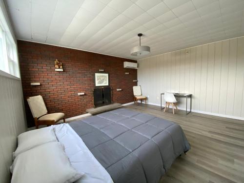 ein Schlafzimmer mit einem großen Bett und einer Ziegelwand in der Unterkunft Private Room Lakeview House- Westmount in Moncton