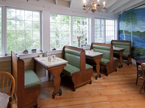 un restaurante con mesas, sillas y ventanas en Mill Falls at the Lake, en Meredith